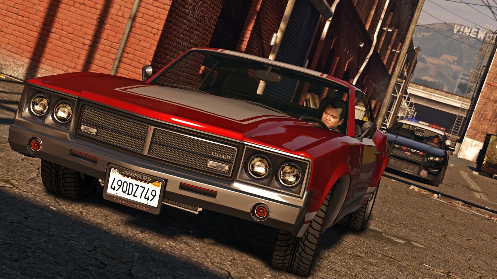 A muscle car chased by a police cruiser through a Los Santos alley, the kind of gameplay FiveM scripts add jobs and rules to