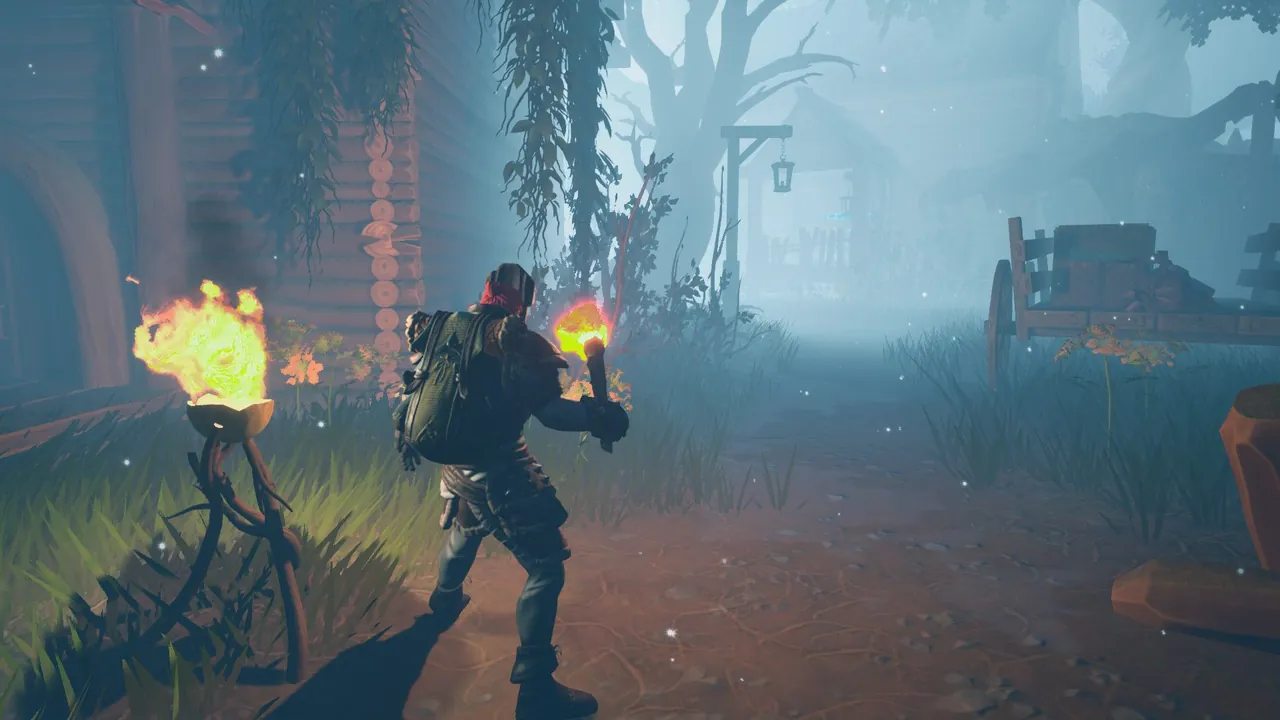 A Frozen Flame player holding a torch on a misty village path at night